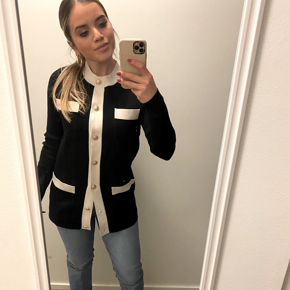 Elegant black and white cardigan with gold buttons.